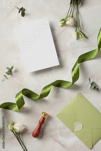 Wedding stationery, invitation mockup, and flowers on marble background. Flat lay, top view, copy space