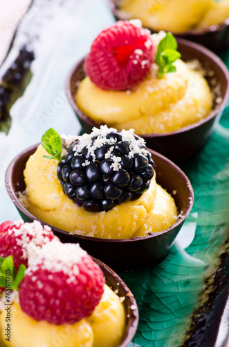 Traditional German chocolate pralines with vanilla pudding and fruits in a chocolate bowl