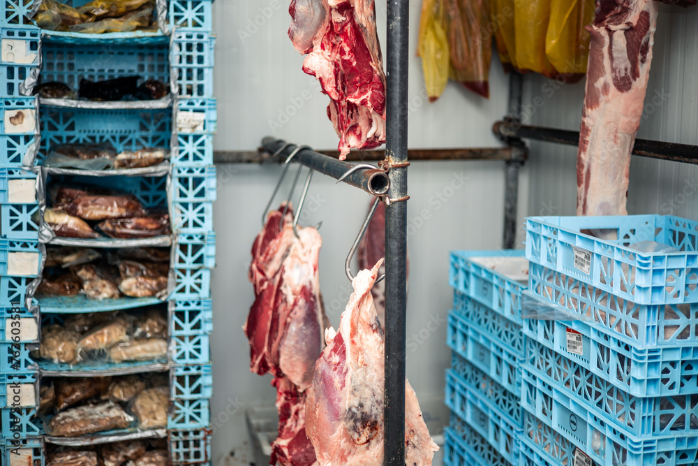 Refrigerated Cold Storage with Boxes of Meat and Beef Hanging on Hooks