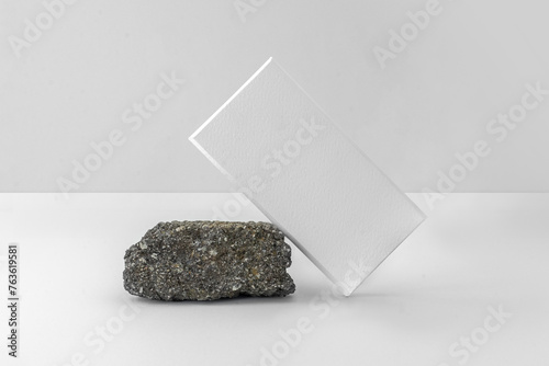 Matte white chocolate box packaging. Blank cardboard mockup. Textured paper. (real photo) 3D render leaning on a rock (ID: 763619581)