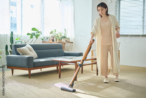 Photos リビングで掃除機をかける20代女性