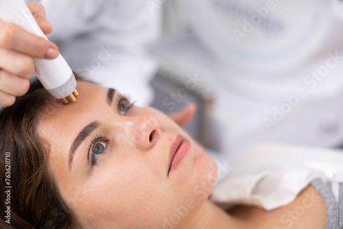 Face of relaxed young woman having radiolifting of her face by means of apparatus for aesthetic procedures