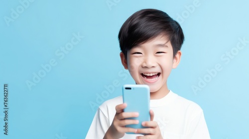 Asian high school teenage boy student with a gadget in his hands. smartphone or tablet for online learning