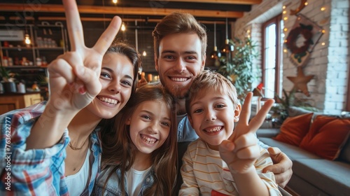 Self-portrait selfie of cheerful excited glad ecstatic family small little brother sister son daughter festive event party joy showing v-sign peace victory morning day in loft industrial interior
