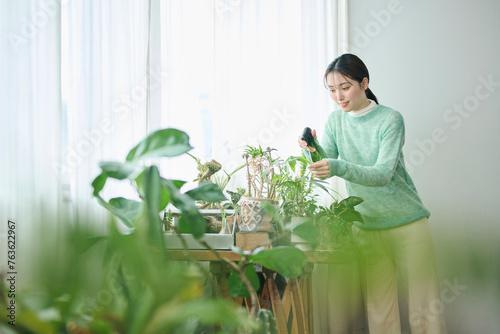 観葉植物の世話をする20代女性