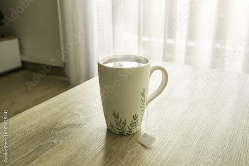 A mug of tea on a wooden table, sun, warm, cold. High quality photo