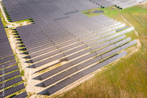 A large field of solar panels is shown from above
