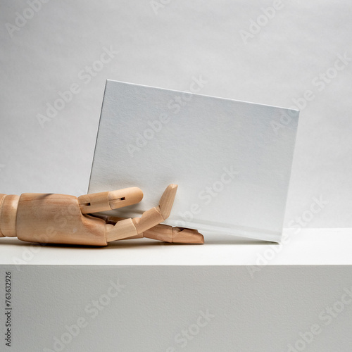 Wooden hand holding. Hardcover book. Matte white. Blank book mockup. Textured paper. (real photo) 3D render on desk.  (ID: 763632926)