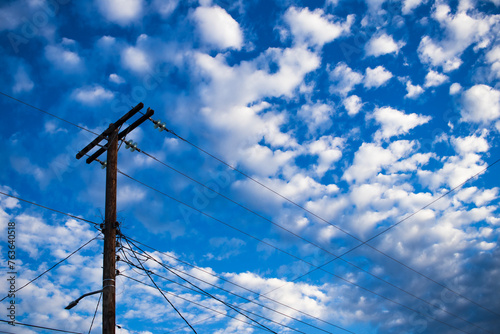 poste de electricidad en cielo azul con nubes