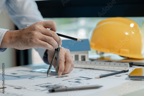 An engineer is working in his office and using various equipment to help with his work. An architect is working in a transparent office filled with documents and a nice atmosphere. photo