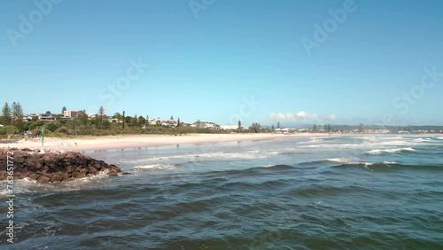 Low over crashing waves on the headland in the early morning looking towards the town