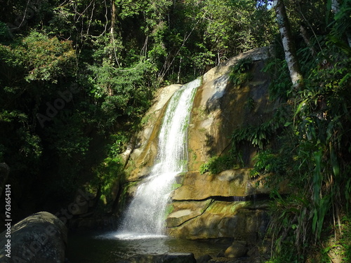 waterfall in the jungle illuminated by a ray of sun