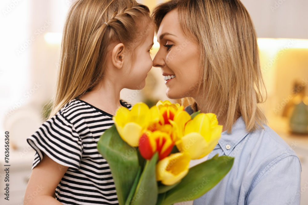 Little daughter congratulating her mom with bouquet of beautiful tulips at home. Happy Mother's Day Little daughter congratulating her mom with bouquet of beautiful tulips at home. Happy Mother's Day
