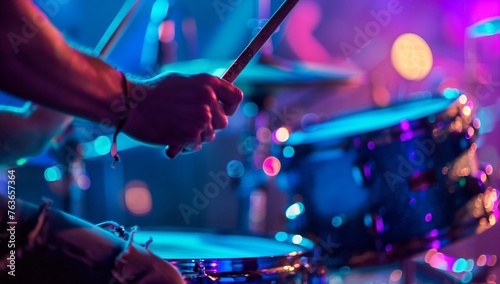 A musician playing a purple drum set with cymbals and drumheads on stage, showcasing their talent on the membranophone musical instrument at a concert photo