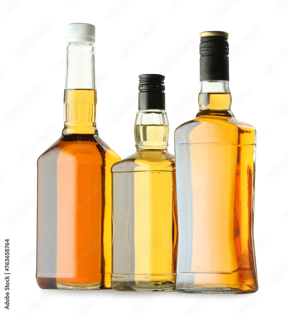 Different sorts of whiskey in glass bottles isolated on white Different sorts of whiskey in glass bottles isolated on white