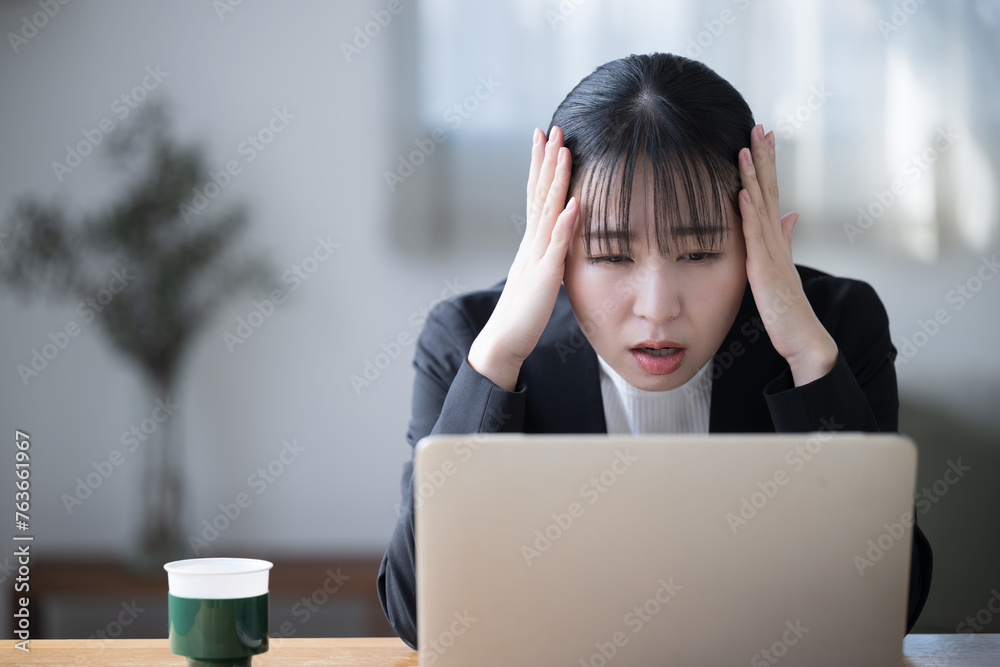 Fototapeta premium Woman with head in front of computer Images of headaches, work problems, failures, mistakes, investments, etc.