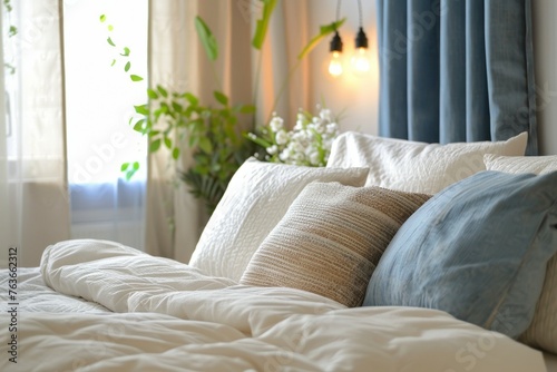 A bed with a white comforter and blue pillows