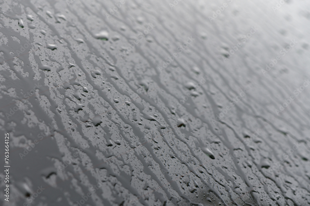 Full frame of the water droplets sliding on a black wet surface.1 Full frame of the water droplets sliding on a black wet surface.1