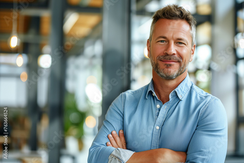 Confident Businessman with Crossed Arms Standing in a Modern Office Environment