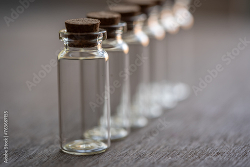 fila de botellas de vidrio vacías con tapa de corcho sobre mesa de madera, formadas en hilera photo