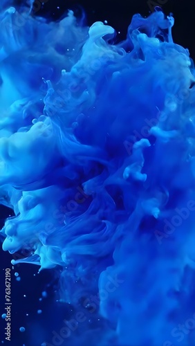 Blue paint ink drops in water, Inky cloud swirling flowing underwater. Abstract isolated smoke explosion for background.