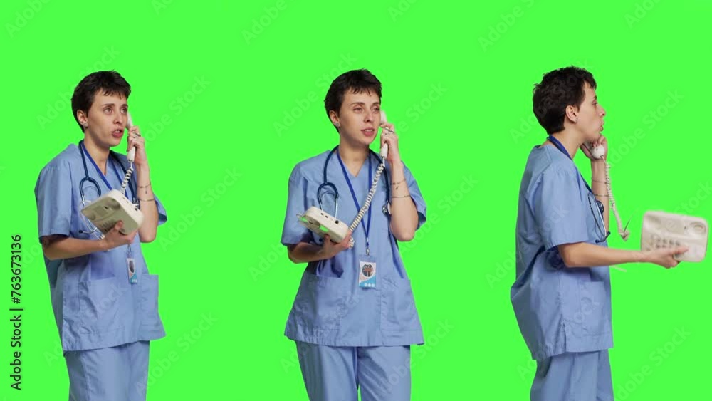 Nurse answering landline phone call to make checkup appointments, talking to patients on telephone with cord against greenscreen backdrop. Health specialist in scrubs uses vintage phone. Camera B. Nurse answering landline phone call to make checkup appointments, talking to patients on telephone with cord against greenscreen backdrop. Health specialist in scrubs uses vintage phone. Camera B.