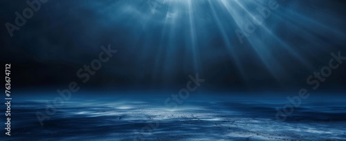 Ethereal rays of light pierce through the misty blue expanse, creating a serene yet powerful abstract vision. © BackgroundWorld