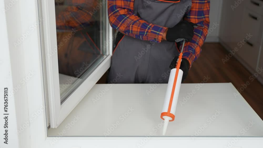 A worker is applying polyurethane foam to fill gap between sash and