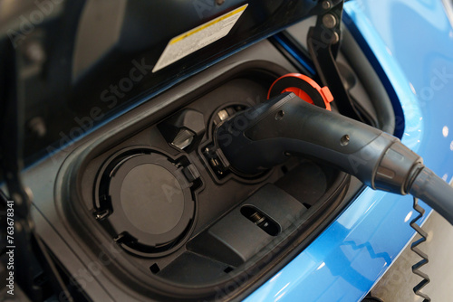 Close-up of an electric car being charged, illustrating the concept of eco-friendly fuel or electric refueling