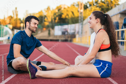 Two athletes stretching after an athletics training session.