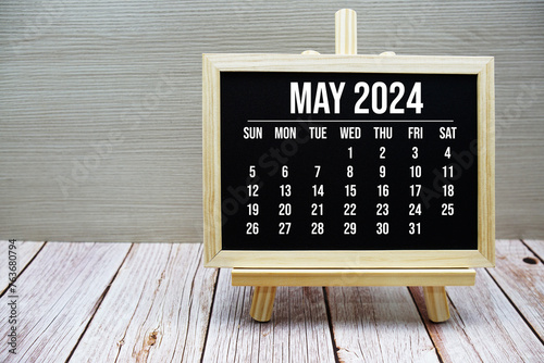 May 2024 monthly calendar on easel stand on wooden background