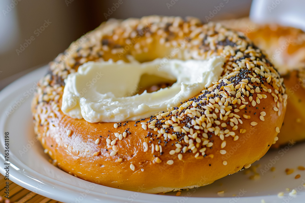 A sesame seed bagel sits on a white plate A sesame seed bagel sits on a white plate