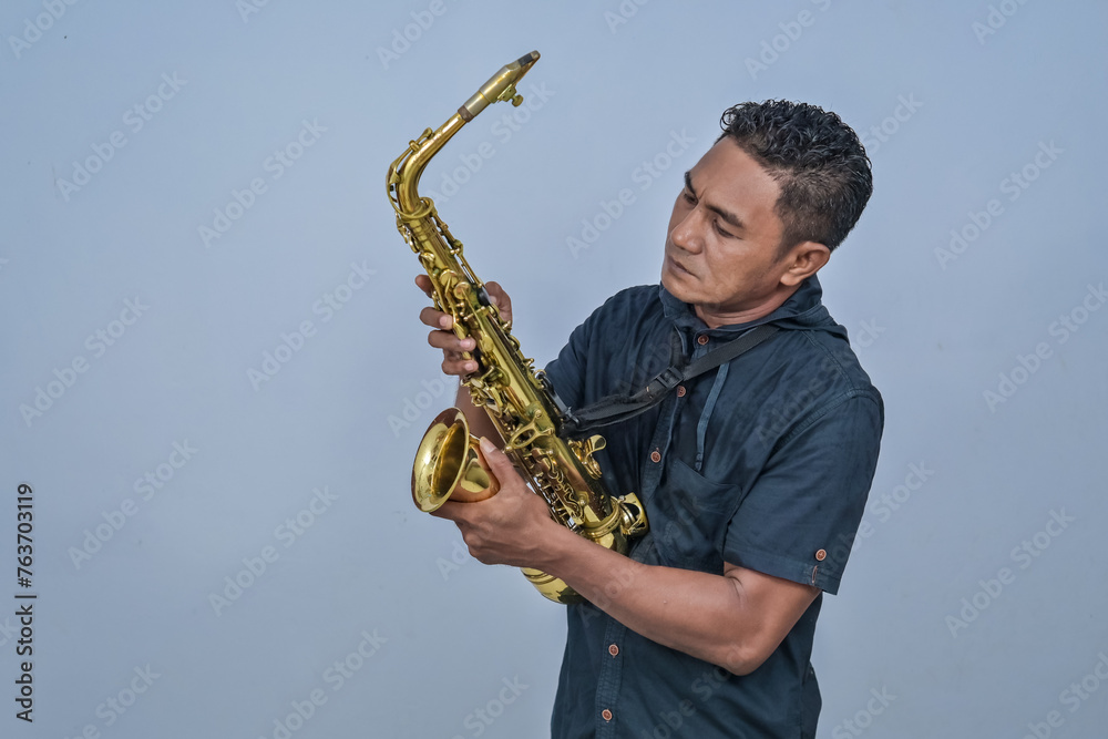 Naklejka premium A man holding a Saxophone