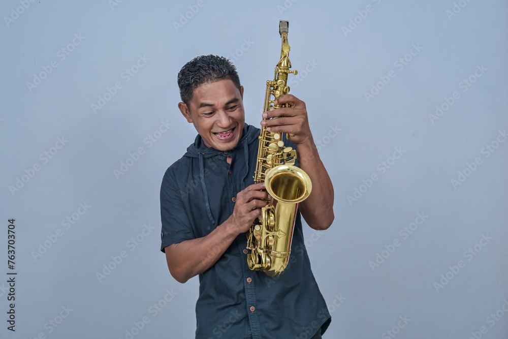 Naklejka premium A man holding a Saxophone