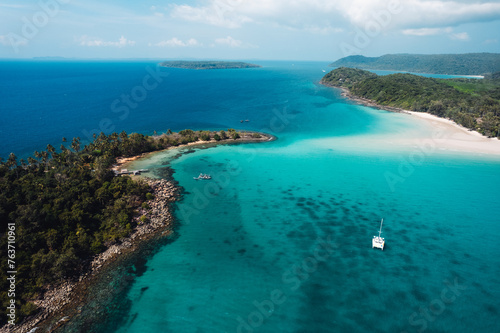 Boat floating on blue water at tropical island