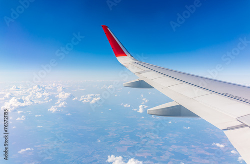 View from the airplane window at a beautiful cloudy sky and the airplane wing