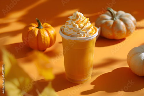 A mug of spicy pumpkin latte with whipped cream. A cup of pumpkin coffee on the  pastel yellow orange background. Autumn winter seasonal coffee drink with pumpkin and cinnamon.