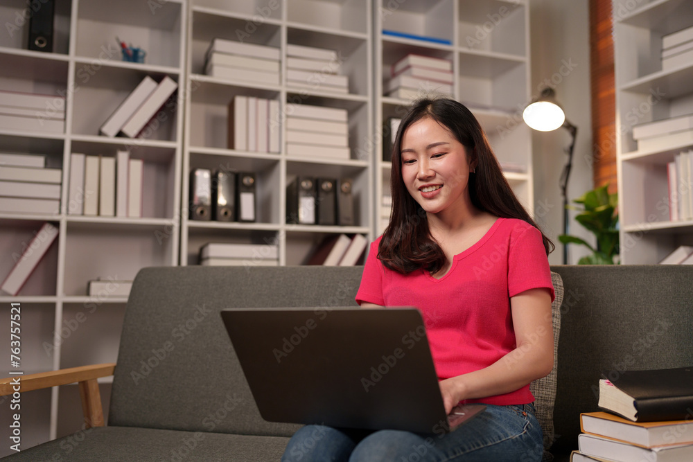 Modern working lifestyle Asian businesswoman sitting on sofa at home office working on laptop online using internet, communication Video calls to receive and communicate information happily. Modern working lifestyle Asian businesswoman sitting on sofa at home office working on laptop online using internet, communication Video calls to receive and communicate information happily.