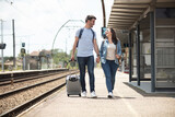 couple at railway station wiring for train travel concept