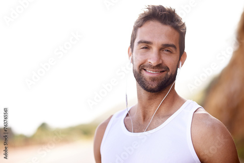 Fitness, headphones and portrait of man in nature for exercise, workout and music for training. Male person, earphones and mockup with smile for streaming, audio or podcast for outdoor morning cardio © Mikolette Moller/peopleimages.com