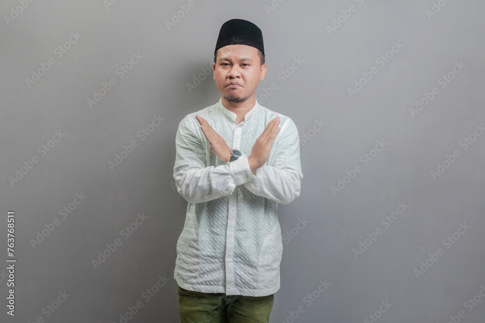 Asian muslim man doing stop sign with cross of the hand Asian muslim man doing stop sign with cross of the hand