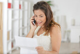 woman on telephone communicating good news received by letter