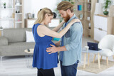 man and pregnant woman dance in loft