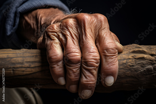Close-up of an Elderly Hand Grasping a Wooden Walking Stick, Symbolizing Age, Experience, and the Journey of Life