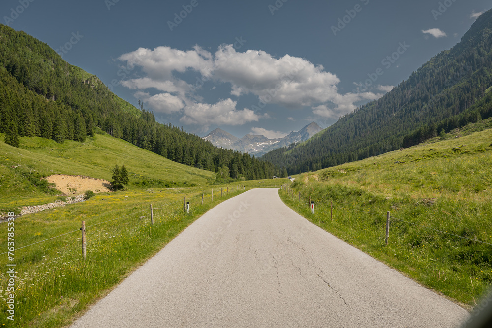 The road towards the Solkpass in austria, one of the mountian passes if you want to evade tunnels or obertauern. Green hills and some clouds, pass in the background. The road towards the Solkpass in austria, one of the mountian passes if you want to evade tunnels or obertauern. Green hills and some clouds, pass in the background.
