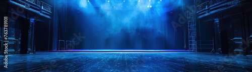 An empty stage awaits bathed in dramatic blue spotlighting