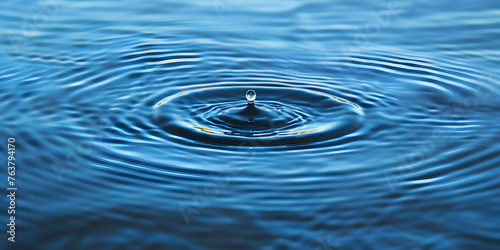 Water drop on blue background. Blue water surface with splash. Clear Waterdrop with circular waves. Splashes closeup. Water splash and falling drop. Splash of the falling drops of water. 