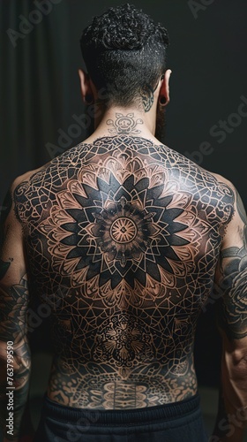 The ancient symbolism of an intricate mandala tattoo on a man's back, its intricate patterns and geometric shapes set against a timeless, solid backdrop.
