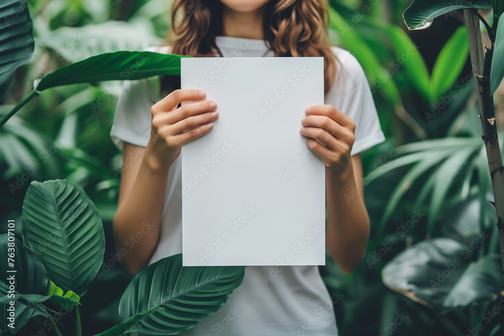 Beautiful young woman holding blank paper in jungle Beautiful young woman holding blank paper in jungle