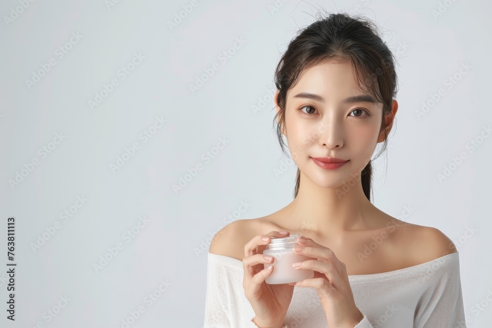 Embracing Radiance: A young woman holds a jar of skincare, her radiant complexion a testament to a healthy beauty regimen. This close-up shot, taken against a soft backdrop. Embracing Radiance: A young woman holds a jar of skincare, her radiant complexion a testament to a healthy beauty regimen. This close-up shot, taken against a soft backdrop.